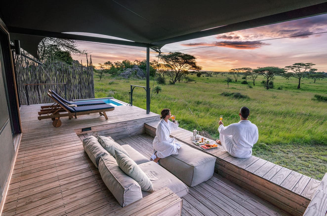 Luxury safari lodge deck overlooking the Serengeti at sunset